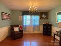 Inviting living room with hardwood floors, a window with lace curtains, and a comfortable armchair at 6708 Nutcracker Pl, Charlotte, NC 28212