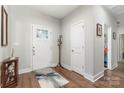 Inviting foyer with wood-look floors, decorative rug, and a coat rack next to the front door at 7516 O'Hara St, Huntersville, NC 28078