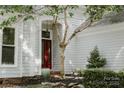 Inviting front porch with a red door, tasteful planters, and well-maintained landscaping at 9141 Covey Hollow Ct, Charlotte, NC 28210