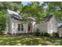 Charming home with red front door, manicured landscaping, and mature shade tree at 9141 Covey Hollow Ct, Charlotte, NC 28210