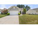 Well maintained home with a two-car garage, luscious green lawn, and mature landscaping at 1031 Fants Grove Ln, Indian Land, SC 29707
