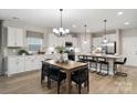 Bright kitchen with white cabinets, stainless steel appliances, and a dining area with seating for six at 1045 Mapletree Ln, Indian Trail, NC 28079