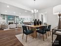 Open-concept dining area flows into living room and kitchen with modern lighting and stylish decor at 1056 Mapletree Ln, Indian Trail, NC 28079