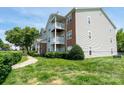 Exterior of condo with multiple balconies and lush green lawn at 10614 Hill Point Ct, Charlotte, NC 28262