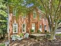 Inviting red brick home exterior featuring a cozy seating area on the front porch and manicured landscaping at 11126 Windgate Ct, Tega Cay, SC 29708