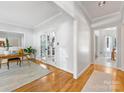 Bright hallway with hardwood floors, white walls, and glass paneled doors leading to other rooms at 11126 Windgate Ct, Tega Cay, SC 29708