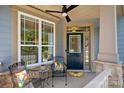 Inviting front porch with stylish seating, ceiling fan, and charming details at 1209 Shelly Woods Dr, Indian Land, SC 29707