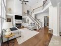 Bright living room with hardwood floors, fireplace, and a staircase leading to the upper level at 163 Shoreline Pkwy, Tega Cay, SC 29708