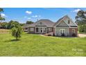 Charming brick home with a sprawling green lawn, showcasing its inviting facade under a bright sky at 2145 Jack Wilson Rd, Shelby, NC 28150