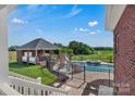 Inviting pool area with a slide, spa, and covered outdoor kitchen, perfect for entertaining and relaxation at 2145 Jack Wilson Rd, Shelby, NC 28150