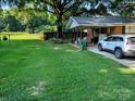 Lush backyard featuring a sprawling lawn, mature trees, and partially fenced yard offering outdoor enjoyment at 2261 Felly Ln, Lancaster, SC 29720