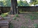 Backyard featuring a large tree, wooden fence, bird house, and wooden chairs, ideal for outdoor relaxation at 2261 Felly Ln, Lancaster, SC 29720