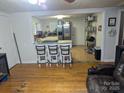 Open living space with hardwood floors and an eat-in kitchen island featuring chairs and a view into the kitchen at 2261 Felly Ln, Lancaster, SC 29720