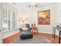 Cozy living area with a plush chair, ottoman, elegant decor, and a serene atmosphere with hardwood floors at 407 Knops Nob Rd, Mooresville, NC 28115