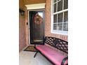 A bench with a wreath hangs on the front door, next to a window with grids at 4204 Canipe Dr, Charlotte, NC 28269