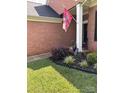 Home's inviting front entrance with manicured landscaping and a decorative flag at 4204 Canipe Dr, Charlotte, NC 28269