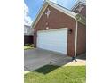 A two-car garage with a white door and brick facade, side view at 4204 Canipe Dr, Charlotte, NC 28269