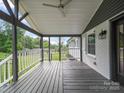 A covered porch with gray painted floors, white railings, and peaceful outdoor view at 430 Edgegreen Dr, Charlotte, NC 28217