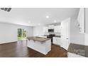 Bright kitchen with granite island, stainless steel appliances, and sliding glass doors to backyard at 462 Janie Cir # 100, Newton, NC 28658