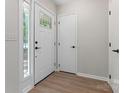 Bright entryway featuring a decorative front door, white trim, and wood-look flooring at 5534 Great Wagon Rd, Charlotte, NC 28215
