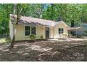 The exterior of this charming home features a well-manicured lawn, lots of trees, and a lovely facade at 5534 Great Wagon Rd, Charlotte, NC 28215