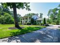 Spacious home with a lush green lawn, mature trees and a long driveway at 711 Yadkin St, Albemarle, NC 28001