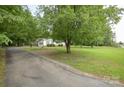 Ranch-style house with long driveway, mature trees, and lush yard at 7645 Robinson Church Rd, Harrisburg, NC 28075