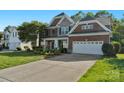 Beautiful two-story home with brick and stone facade, attached two-car garage, and landscaped front yard at 8325 Burgundy Ridge Dr, Harrisburg, NC 28075