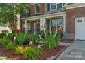 Close-up of front of home with brick and stone and lush landscaping at 8325 Burgundy Ridge Dr, Harrisburg, NC 28075
