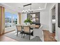 Elegant dining room featuring modern light fixture, stylish chairs, large windows, and white and gray decor at 1045 Waxhaw Crossing Dr, Waxhaw, NC 28173