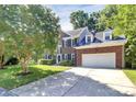 Charming two-story brick home featuring a two-car garage, dormer windows, and well-manicured landscaping at 11305 Hunters Landing Dr, Charlotte, NC 28273