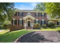 Beautiful two-story brick home with a well-maintained lawn and classic architectural details at 1134 Willow Oaks Trl, Matthews, NC 28104