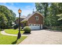 Brick home features a three-car garage and manicured landscaping at 1134 Willow Oaks Trl, Matthews, NC 28104