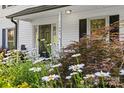 Inviting front entrance with a black door, decorative plants, and a well-maintained flower bed at 11401 Lone Star Cir, Charlotte, NC 28226