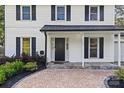 Welcoming front porch with brick pavers, lush landscaping, and a classic black front door at 11401 Lone Star Cir, Charlotte, NC 28226