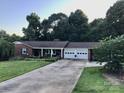 Lovely brick home with an attached two-car garage, lush lawn, and beautiful landscaping at 137 Proust Rd, Statesville, NC 28625