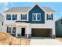 New construction two-story home with white siding, blue accents, a two-car garage, and stone details at 2030 Puddle Pond Rd, Indian Trail, NC 28079