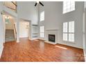 Spacious living room with a fireplace and large windows with plantation shutters and wood floors at 2830 Grosbeak Ln, Charlotte, NC 28269