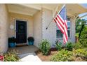 Welcoming front door adorned with a wreath, complemented by potted plants and a brick facade at 3006 Constitution Ln, Gastonia, NC 28056