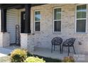 Cozy front porch with chairs, brick accents, and a 'Welcome' sign, creating an inviting entrance at 305 Pleasant Hill Se Dr, Concord, NC 28025