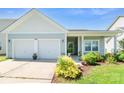 Inviting single-story home featuring a two-car garage, manicured lawn, and charming entrance at 3296 Saddlebrook Dr, Midland, NC 28107