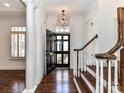 Inviting entryway with wood floors, a statement light fixture, and stairs leading to the upper levels at 344 S Laurel Ave, Charlotte, NC 28207