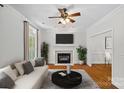 Bright living room with a fireplace, hardwood floors, a ceiling fan, and comfortable seating area at 3535 Selwyn Farms Ln, Charlotte, NC 28209