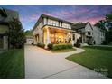 Beautiful two-story home with a charming front porch, lush landscaping, and a long driveway leading to a detached garage at 508 Mcalway Rd, Charlotte, NC 28211