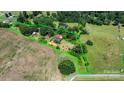 Expansive aerial view of rural acreage featuring mature trees, open fields, and charming residential structures within a defined property line at 5560 Springs Rd, Conover, NC 28613