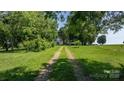 Picturesque driveway winding through lush greenery, leading to a charming home nestled in a serene, tree-filled setting at 5560 Springs Rd, Conover, NC 28613