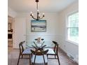 Inviting dining room with contemporary light fixture, modern art, and bright window views at 5727 Faulconbridge Rd, Charlotte, NC 28227