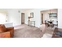 Comfortable living room featuring neutral colored carpet, traditional decor, and lots of natural light at 5727 Faulconbridge Rd, Charlotte, NC 28227