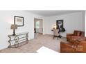 Cozy living room with light colored carpet, study nook, and comfortable leather furniture at 5727 Faulconbridge Rd, Charlotte, NC 28227