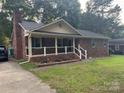 Attractive single-story brick home featuring a inviting front porch and a well-maintained lawn at 6039 Donna Dr, Charlotte, NC 28213